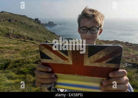 UK, Cornwall, portrait of boy taking a selfie at Land's End with his digital tablet Stock Photo