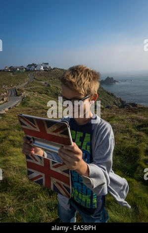 UK, Cornwall, boy taking a selfie at Land's End with his digital tablet Stock Photo