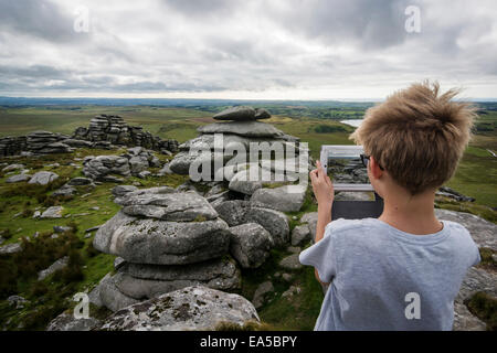 UK, Cornwall, boy photographing landscape at Bodmin Moor with his digital tablet Stock Photo