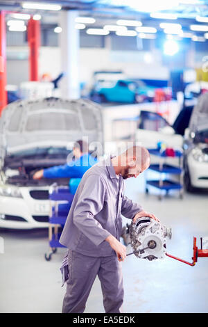Car mechanic working on gearbox in repair garage Stock Photo - Alamy