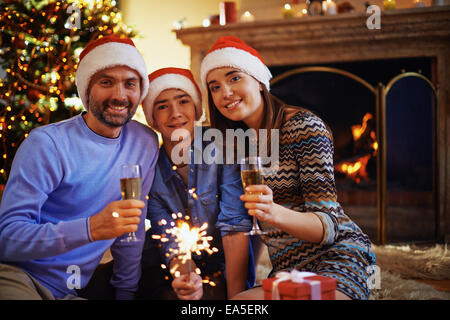 Family of three looking at camera on Christmas evening Stock Photo