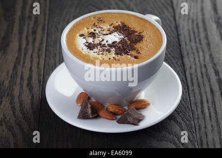 cup of freshly made cappuccino with latte art, on oak table Stock Photo