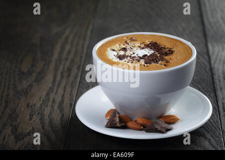 cup of freshly made cappuccino with latte art, on oak table Stock Photo