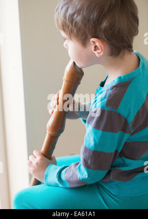 Little girl playing wooden flute Stock Photo