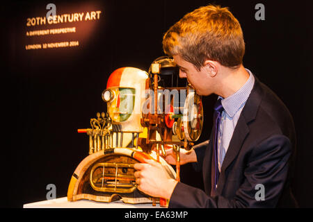 London, UK. 7th November, 2014. Sotheby’s is to hold its Inaugural 20TH Century Art– A Different Perspective sale on November 12th in London, where collectors will have the opportunity to acquire some highly regarded examples of avante-garde and abstract art. PICTURED: Sotheby's Richard Lowkes examines Gerrg Hartmann's 'Mechanical Head', which is expected to fetch between £15,000 to £20,000 at auction. Credit:  Paul Davey/Alamy Live News Stock Photo