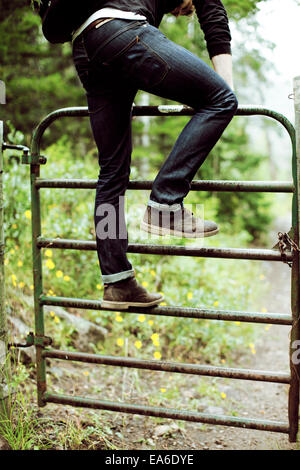 Young man climbing up barrier