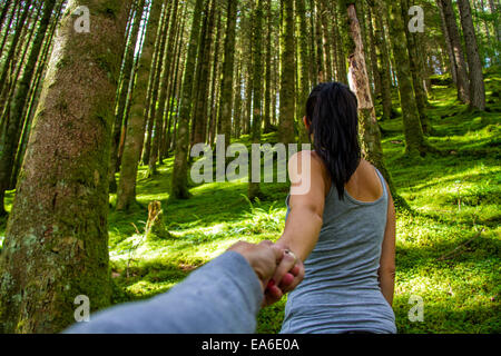 Man and woman holding hands in forest Stock Photo