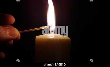 Man lighting a candle with a match Stock Photo