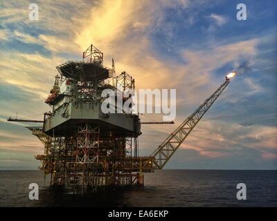 Offshore Oil and Gas platform with Oil Jack Up rig at sunset Stock Photo