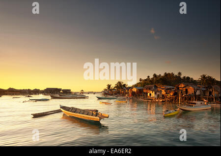Malaysia, Sabah, Small boats and Sea Gypsy huts at sunrise Stock Photo