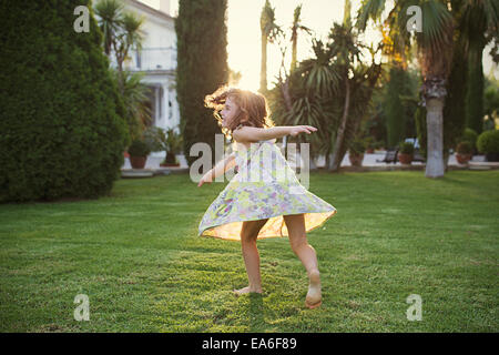 Girl spinning around in garden