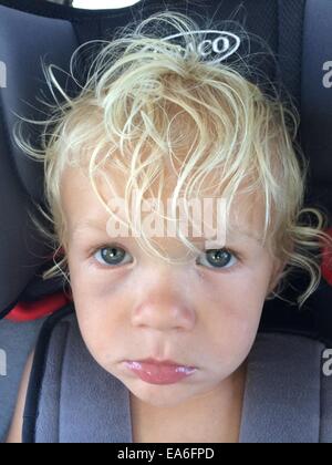 Unhappy boy sitting in car seat Stock Photo