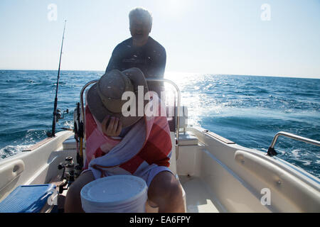 Italy, Puglia, TA, Ginosa, Marina di Ginosa, Men fishing on boat in Italy Stock Photo