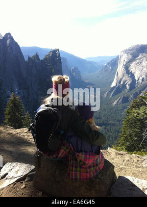 Mother and daughter sitting a rock looking at view, Yosemite National Park, California, USA Stock Photo