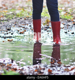 Girl wearing wellington boots standing in puddle Stock Photo