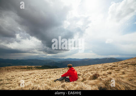 Young man sitting in field Stock Photo