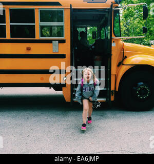 Smiling Girl getting off school bus, Wisconsin, United States