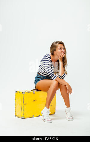 girl sitting on a suitcase Stock Photo