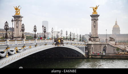 Paris, France - August 07, 2014: People walking on the Pont Alexandre III (Alexander III bridge) in a rainy summer day Stock Photo