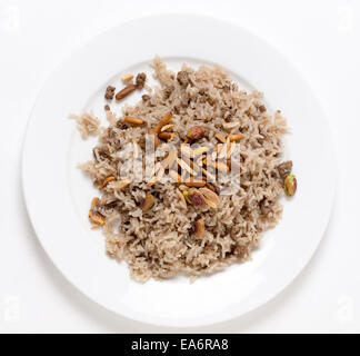 Lebanese spiced rice with minced beef and garnished with freshly toasted nuts on a plate viewed from above Stock Photo