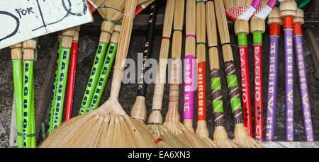 Colorful handmade souvenir straw fan brooms for sale at a roadside stand in the Philippines. Stock Photo