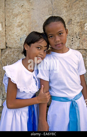 Two preteen Filipino girls in white dresses ready for Catholic church mass at Dimiao Town, Bohol Island, Philippines. Stock Photo