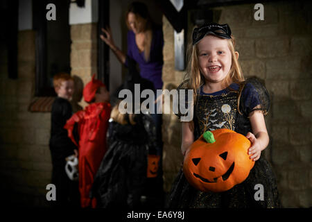 Halloween Party With Children Trick Or Treating In Costume Stock Photo