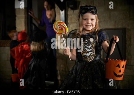 Halloween Party With Children Trick Or Treating In Costume Stock Photo