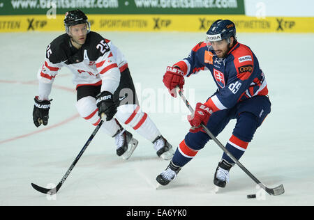Munich, Germany. 07th Nov, 2014. Canada's Micki Dupont (L) and Slovakia's Roman Rac during the Deutschland Cup match between Canada and Slovakia in the Olympic Eissporthalle in Munich, Germany, 07 November 2014. Photo: ANDREAS GEBERT/dpa/Alamy Live News Stock Photo