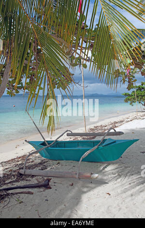 Blue pontoon boat sits on white sandy beach on Pandan Island, Palawan, Philippines, a popular tourist vacation spot. Stock Photo