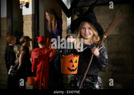 Halloween Party With Children Trick Or Treating In Costume Stock Photo