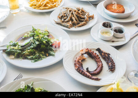 Table in greek restaurant. Salat and fish Stock Photo