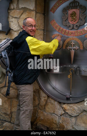 Bodegas Irache Wine Fountain Navarra Spain, on the Camino De Santiago De Compostela. Pilgrim taking a free wine sample. Stock Photo