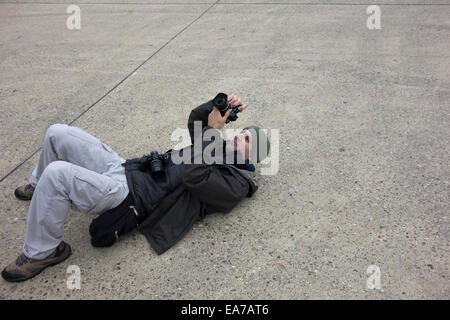 Man photographing while lying on the ground