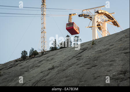The Summit Skyride cable car is lit by the setting sun as it tops the 825 foot granite wall at Stone Mountain Park in Atlanta. Stock Photo