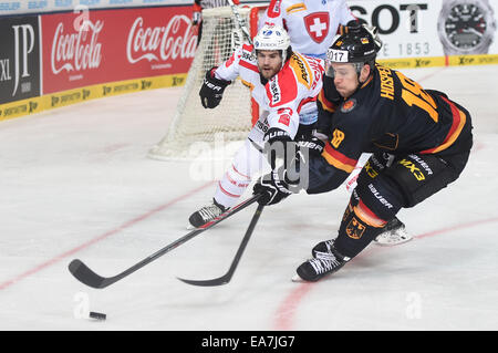 Munich, Germany. 07th Nov, 2014. Germany's Kai Hospelt (R) and Switzerland's Dominik Schlumpf in action during the German Cup match for ice hockey between Germany and Switzerland at the Olympia Ice Rink in Munich, Germany, 07 November 2014. Photo: ANDREAS GEBERT/dpa/Alamy Live News Stock Photo