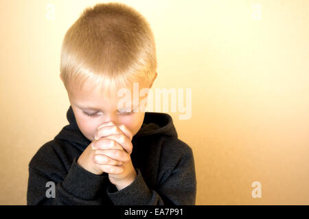 Little young beautiful boy (child, kid) spiritual peaceful praying and wishing, horizontal, copy space. Stock Photo