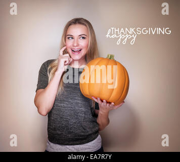 Happy woman with ripe orange pumpkin isolated on beige background, traditional American holiday decoration, Thanksgiving day Stock Photo