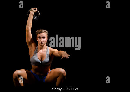 This is a woman doing a kettle bell snatch. Stock Photo
