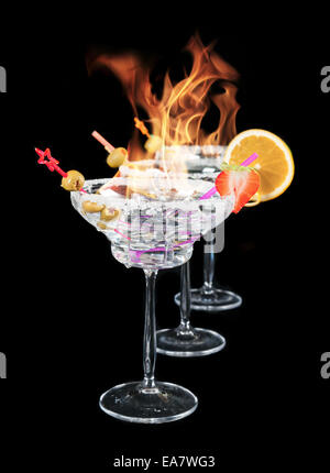 Glasses of alcohol cocktails burning on top, isolated on black background Stock Photo