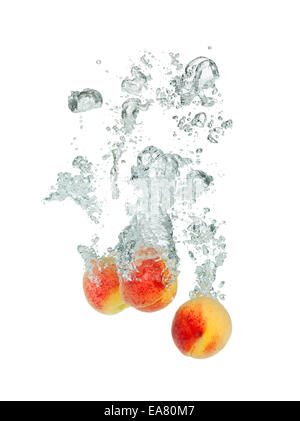 Isolated shot of apricots falling into water, isolated on white background Stock Photo