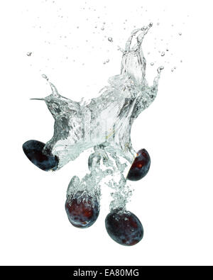 Isolated shot of plums falling into water, isolated on white background Stock Photo