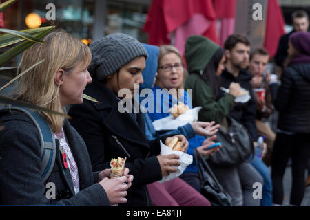 People eating at the Real Food Market. Held weekly, Friday-Sunday, on Southbank Centre Square, it hosts over 40 small producers and independent traders of  fresh, high quality, great value food and drink. Stock Photo