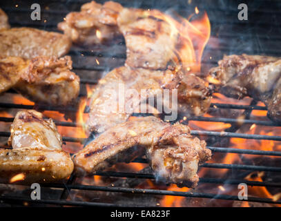 Chicken wings on barbecue grill with fire Stock Photo