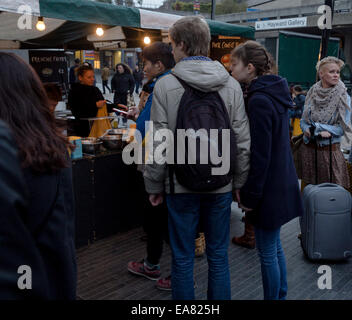 People queuing at the corean stall of the Real Food Market. Held weekly, Friday-Sunday, on Southbank Centre Square, the market hosts over 40 small producers and independent traders of  fresh, high quality, great value food and drink. Stock Photo