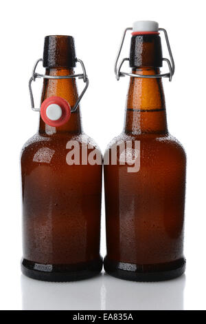 Closeup of two cold swing top brown beer bottles covered with condensation, one bottle is open. Vertical format on white with re Stock Photo