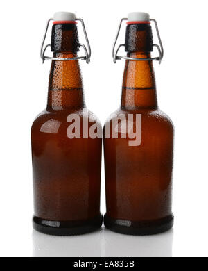 Closeup of two cold swing top brown beer bottles covered with condensation. Vertical format on white with reflection. Stock Photo