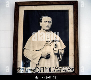 A framed 19th-century photographic portrait of Belgian missionary priest Joseph De Veuster, best known to the world as Father Damien, hangs in St. Joseph's Church that he built while serving the Hawaiian leper colony elsewhere on the island of Molokai, Hawaii, USA. More than 700 patients with leprosy (Hansen's disease) had been isolated there by the time Damien arrived in 1873. He later suffered the same infectious disease and died in the colony in 1889. Father Damien was canonized a saint in the Catholic Church In 2009. His St. Joseph's Church has since been renamed St. Damien's Church. Stock Photo