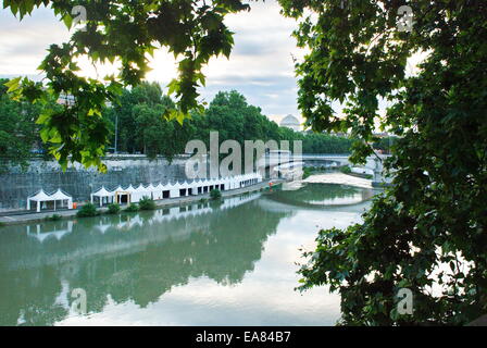 Early morning view of Tiber River in Rome, Italy lined with white tents in preparation for the event summer festival. Stock Photo