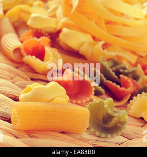 closeup of a pile of different uncooked pasta, such as tortellini, tagliatelle or penne rigate, with a filtered effect Stock Photo